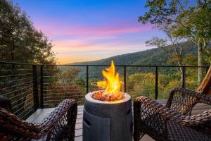 a fire pit sitting on a deck with two chairs at Art & Soul in Lyndhurst
