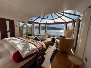 a bedroom with a large bed and a large window at TiticacaMarkaLodge in Puno