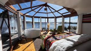a bedroom with a tub and a large glass window at TiticacaMarkaLodge in Puno +44 photos