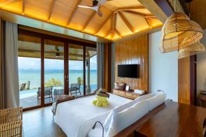 a bedroom with a large white bed and a television at SINAE Phuket Luxury Hotel in Phuket