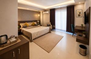 a bedroom with a bed and a desk and a television at Kailashi Hotel Har ki pauri in Haridwār