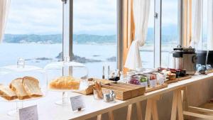 a counter with bread and other items on it with a window at Marine Hotel Harimo in Hamada +51 photos
