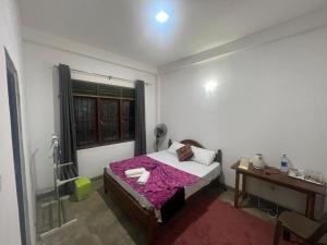 a bedroom with a bed and a desk and a window at D&D Holyday Homes in Kandy