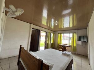 a bedroom with a bed in a room with windows at Hospedaje Las Cabañas in Batán