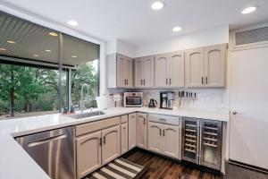 a kitchen with white cabinets and a large window at Prescott Mountain Luxury Escape! in Prescott