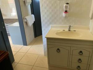 a white bathroom with a sink and a shower at Top1Capricorn in The Range