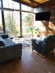 a living room with a couch and a large window at Cabañas Alturas Don Gaspar in Recinto