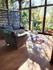 a living room with a couch and a large window at Cabañas Alturas Don Gaspar in Recinto