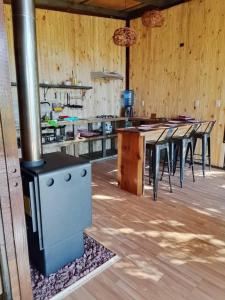 a kitchen with a stove and tables in a room at Cabañas Alturas Don Gaspar in Recinto