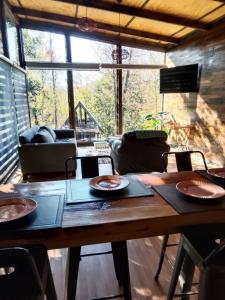 a living room with a wooden table with plates on it at Cabañas Alturas Don Gaspar in Recinto +2 photos