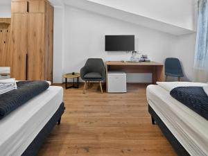 a bedroom with two beds and a desk with a computer at ParkNest - Apartmani i sobe in Apatin
