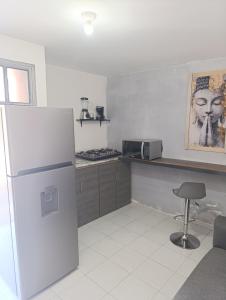 a kitchen with a refrigerator and a chair in it at Departamento faja de oro in Salamanca