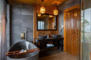 a bathroom with two sinks and a large tub at SINAE Phuket Luxury Hotel in Phuket
