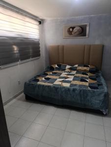 a bedroom with a bed with a checkered blanket at Departamento faja de oro in Salamanca