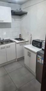 a white kitchen with a sink and a stove at Dpto central y remodelado in Valdivia