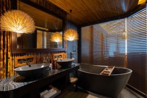 a bathroom with two sinks and a large tub at SINAE Phuket Luxury Hotel in Phuket