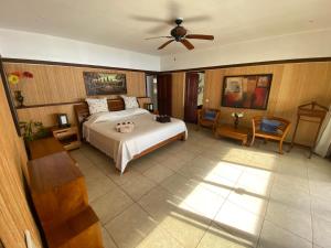 a bedroom with a bed and a ceiling fan at Villa Paradise Tahiti Mata Miti in Punaauia +73 photos