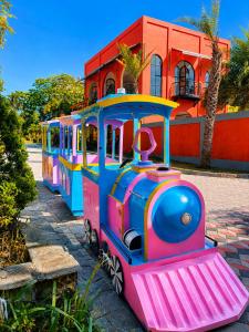 a toy train is parked in front of a building at Onsen Resort Kaliurang in Mantaak