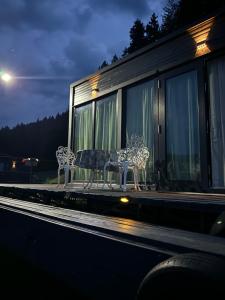 two benches sitting on the side of a building at Black Swan Lakehouse in Bicaz