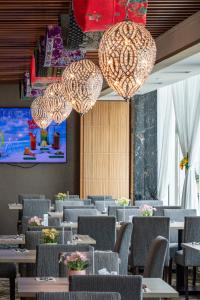 a dining room with tables and chairs and chandeliers at NU Hotel in Bintulu