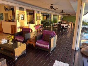a deck with chairs and a table and a restaurant at Villa Paradise Tahiti Mata Miti in Punaauia