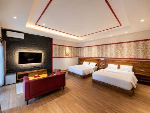 a hotel room with two beds and a flat screen tv at C Family Hotel in Citeureup 1