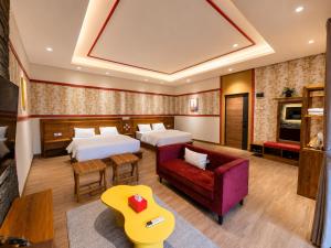 a hotel room with two beds and a couch at C Family Hotel in Citeureup 1