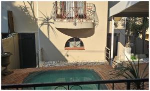a house with a small swimming pool in a courtyard at Lilly by the road in Durban
