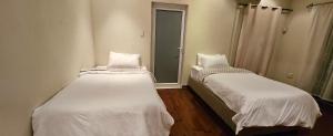 two beds sitting in a room with a mirror at Lilly by the road in Durban
