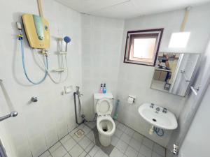 a bathroom with a toilet and a sink at Tiktoki Apartment 15C Kijal in Kijal +3 photos