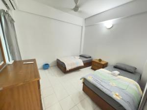 a bedroom with two beds and a dresser in it at Tiktoki Apartment 15C Kijal in Kijal