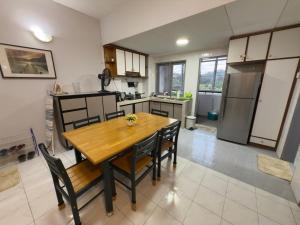 a kitchen with a wooden table and some chairs at Tiktoki Apartment 15C Kijal in Kijal