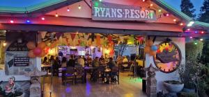 Eine Gruppe von Menschen sitzt nachts in einem Restaurant. in der Unterkunft Ryans Resort in Prasat