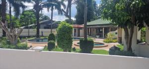 Ein Haus mit Garten, Pool und Bäumen in der Unterkunft Ryans Resort in Prasat