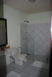 a bathroom with a toilet and a glass shower at Casa Girassois in Pipa +39 photos