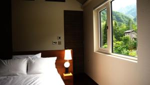 a bedroom with a bed and a window at THE OneThird HAKUBA Slopefront Villas in Hakuba +28 photos