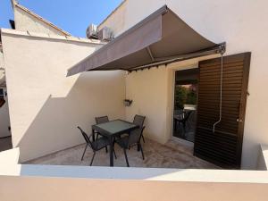 a patio with a table and chairs on a balcony at Sexty-nine, villa 69 héliovillage in Cap d'Agde +19 photos