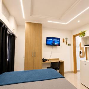 a bedroom with a bed and a desk and a tv at Apartamento completo e moderno com ar condicionado e piscina no centro do RIO in Rio de Janeiro