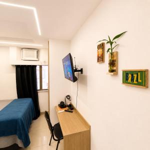 a room with a bed and a desk and a tv at Apartamento completo e moderno com ar condicionado e piscina no centro do RIO in Rio de Janeiro +28 photos