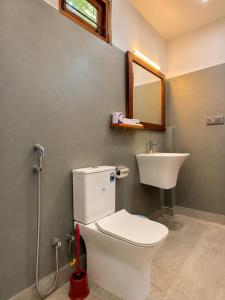 a bathroom with a toilet and a sink at The Oshin Villa in Trincomalee