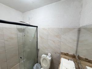 a bathroom with a toilet and a glass shower at Ap em bairro nobre com garagem e ar in Sobral