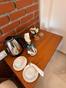 a wooden table with a tea kettle and plates on it at The Oshin Villa in Trincomalee
