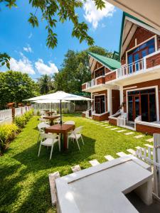 a patio with tables and chairs on the lawn of a house at The Oshin Villa in Trincomalee +29 photos