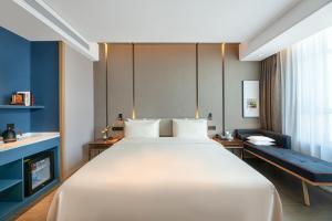 a bedroom with a large white bed and a fireplace at Atour Hotel Lanzhou Xigu in Lanzhou +16 photos