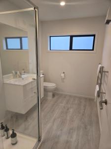 a bathroom with a shower and a sink and a toilet at Stylish townhouse in Te Aroha +7 photos