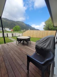 a patio with a table and chairs on a deck at Stylish townhouse in Te Aroha
