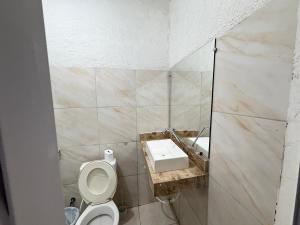 a bathroom with a toilet and a sink at Ap em bairro nobre com garagem e ar in Sobral