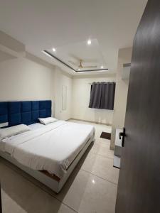 a bedroom with a large bed with a blue headboard at Hotel Durga Palace in Ujjain