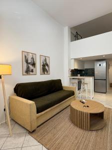 a living room with a couch and a table at Tailor Urban Loft Thiva in Thiva