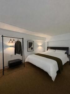 a bedroom with a large white bed and a coat rack at Tailor Urban Loft Thiva in Thiva